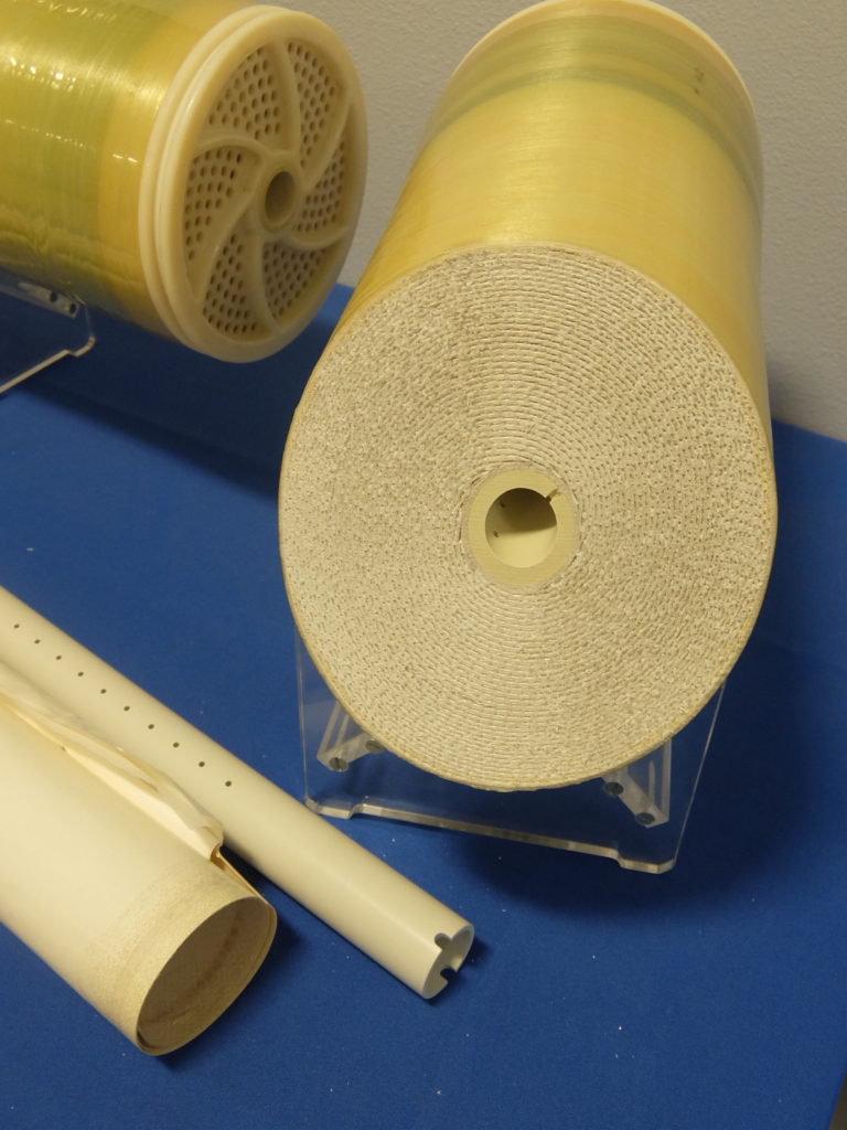 Pipe-like cylinder wrapped in white and tan plastic and mesh,.